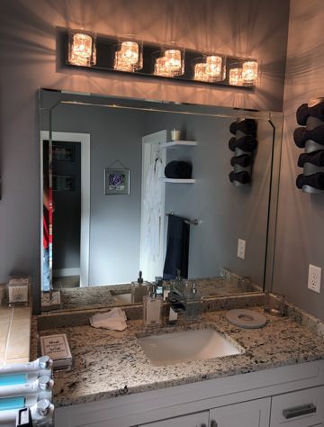 A bathroom with a sink and a large mirror.