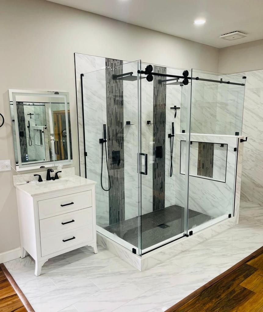 A bathroom with a sliding glass shower door , sink and mirror.