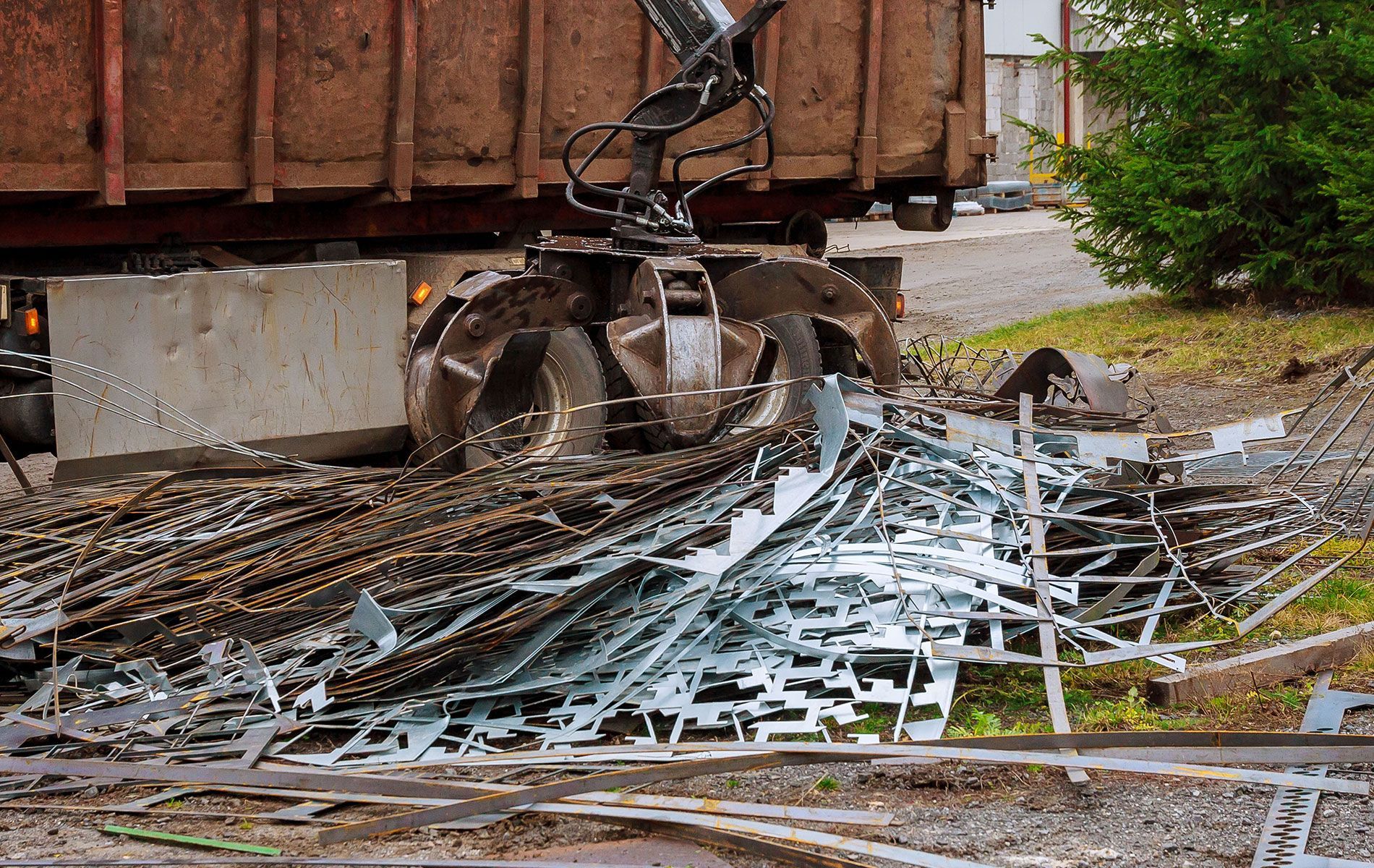 A dumpster is being filled with scrap metal.