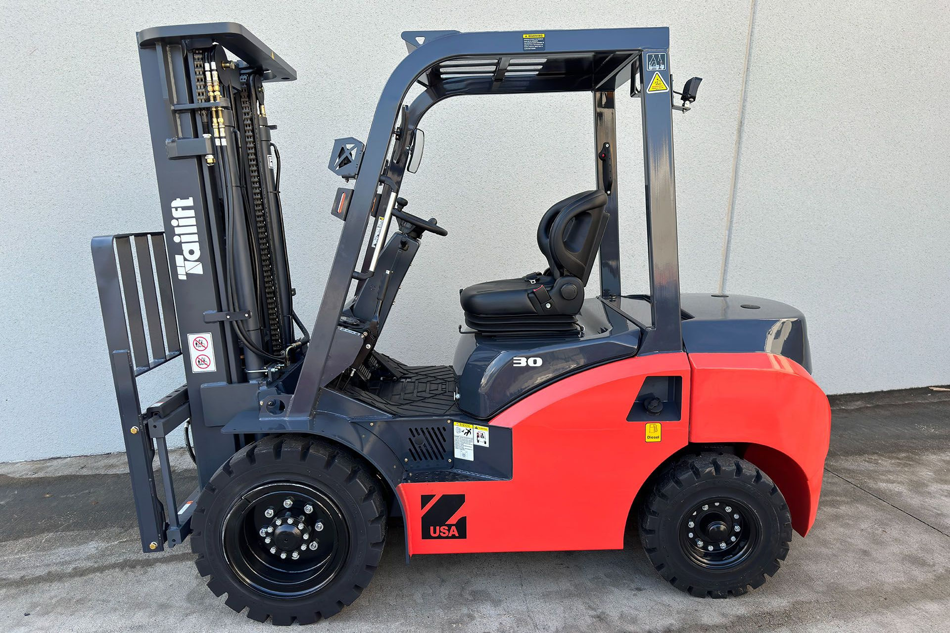 Red and gray forklift parked outside a building.