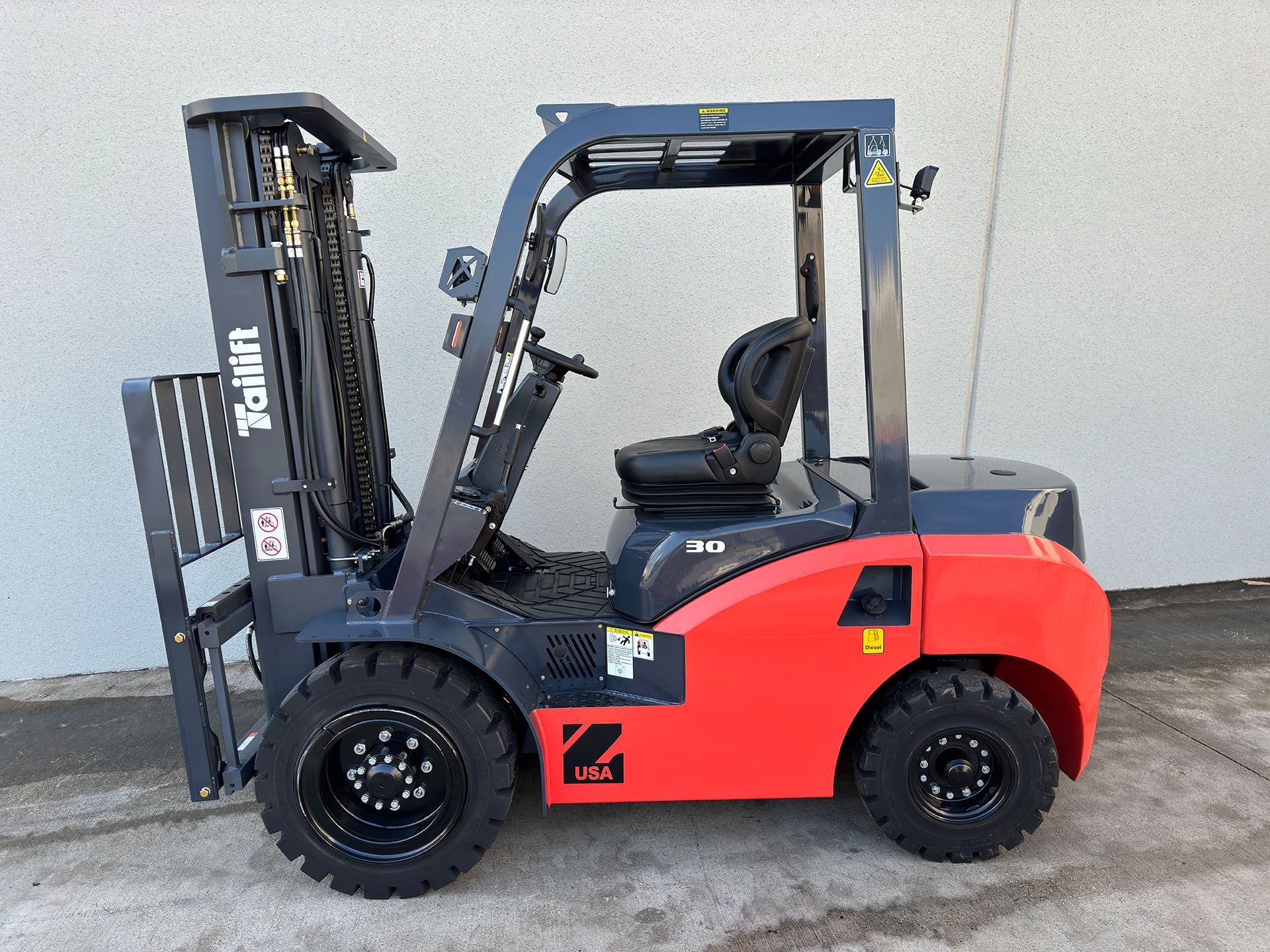 Red and gray forklift parked outside a building.