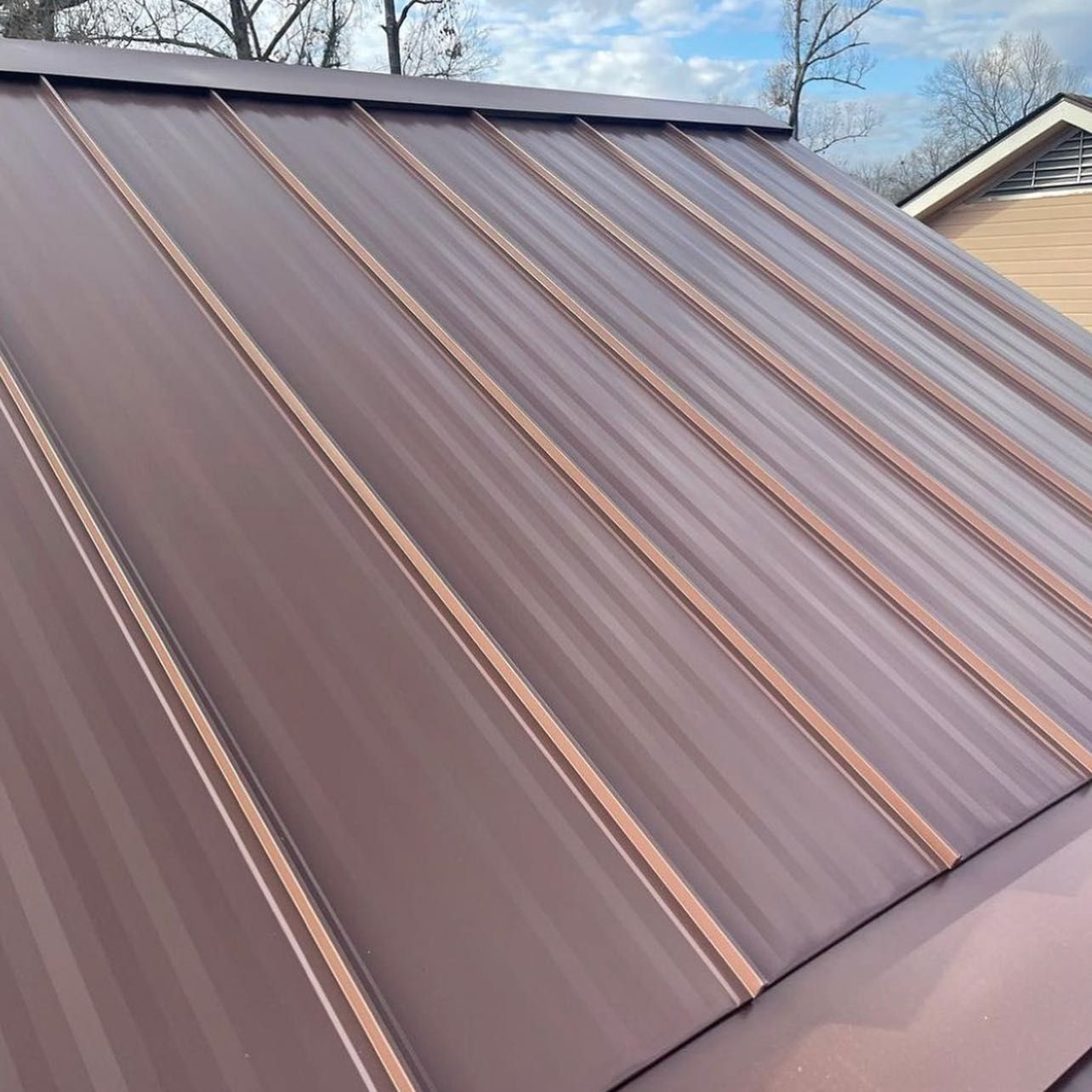 Brown metal roof with vertical ribs, angled towards the viewer.