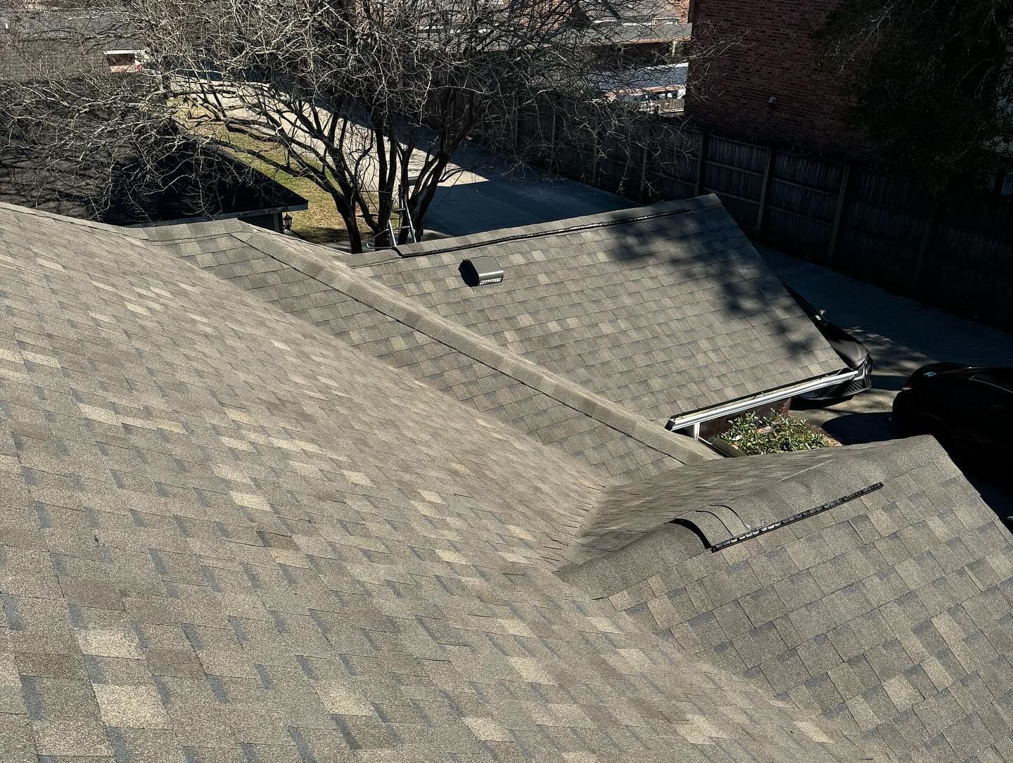 Brown shingled roof viewed from above, with a chimney and gutters visible.