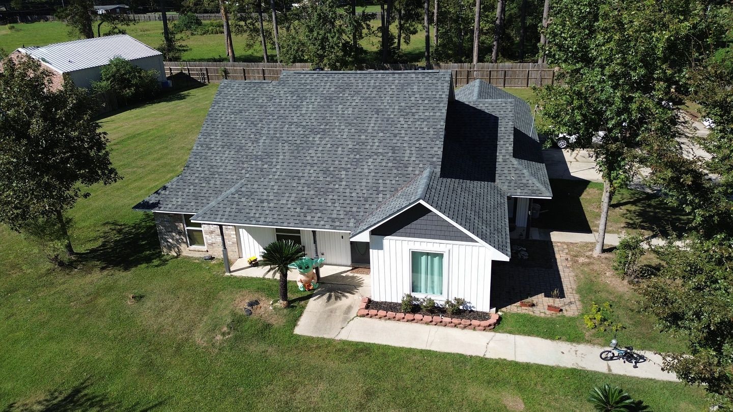 White house with gray roof and green yard.