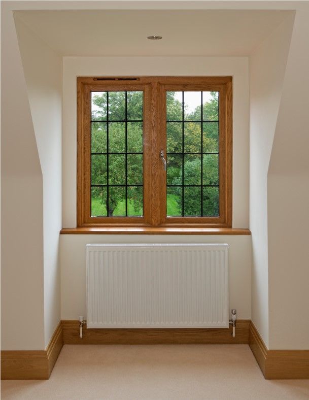 Small room with a wood-framed window, green view outside, and a white radiator below.