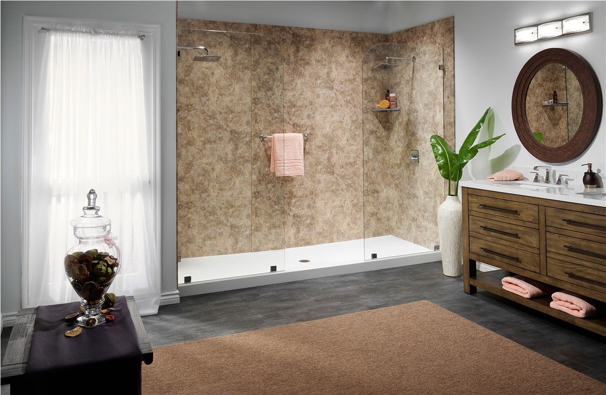 Spa bathroom with a white tub, textured wall, wood vanity, plants, and a large round mirror.