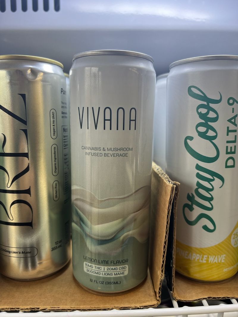 Three cans of soda are sitting on a shelf including viviana and stay cool