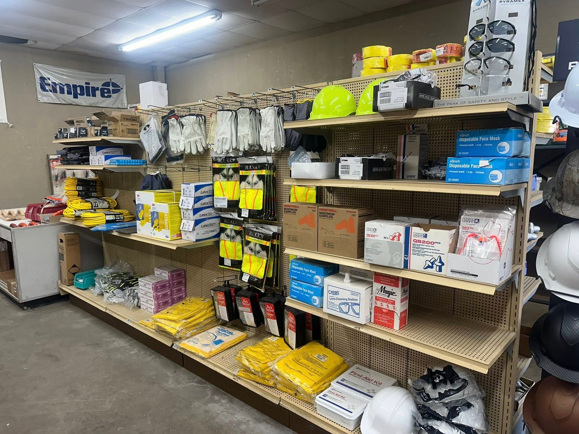 Shelves stocked with various work safety equipment and supplies, in a store setting.