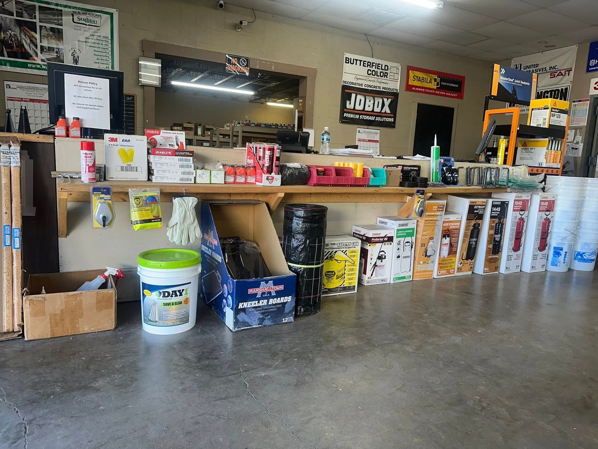 Interior view of a hardware store. Shelves display paint cans, tools, and supplies.