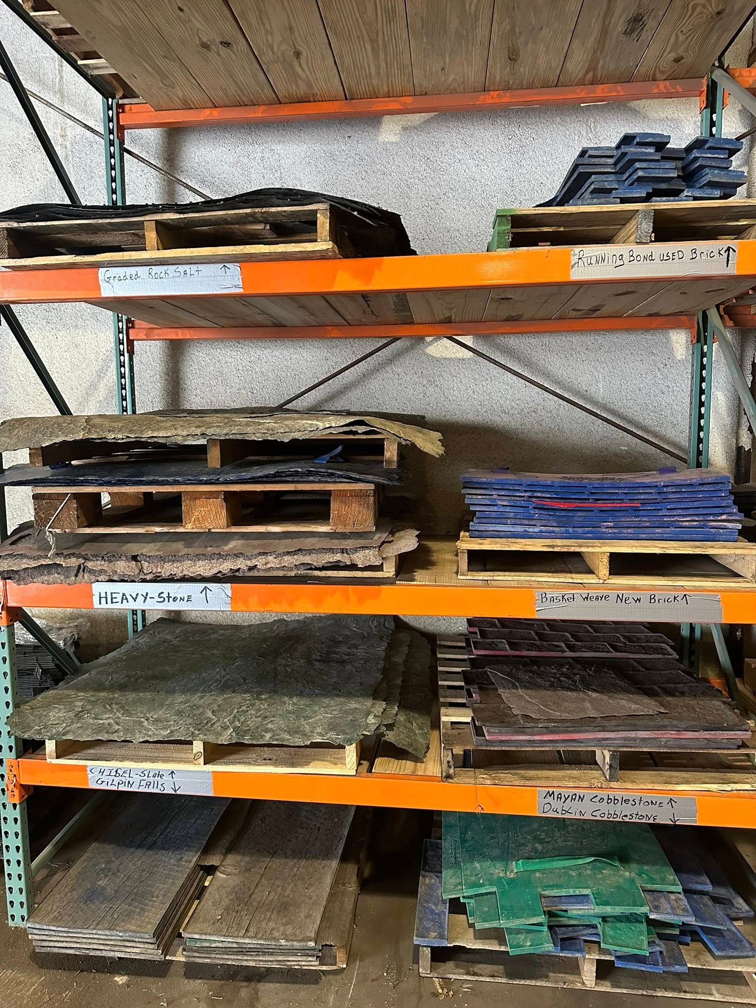 Shelving unit with multiple pallets holding various colored materials.