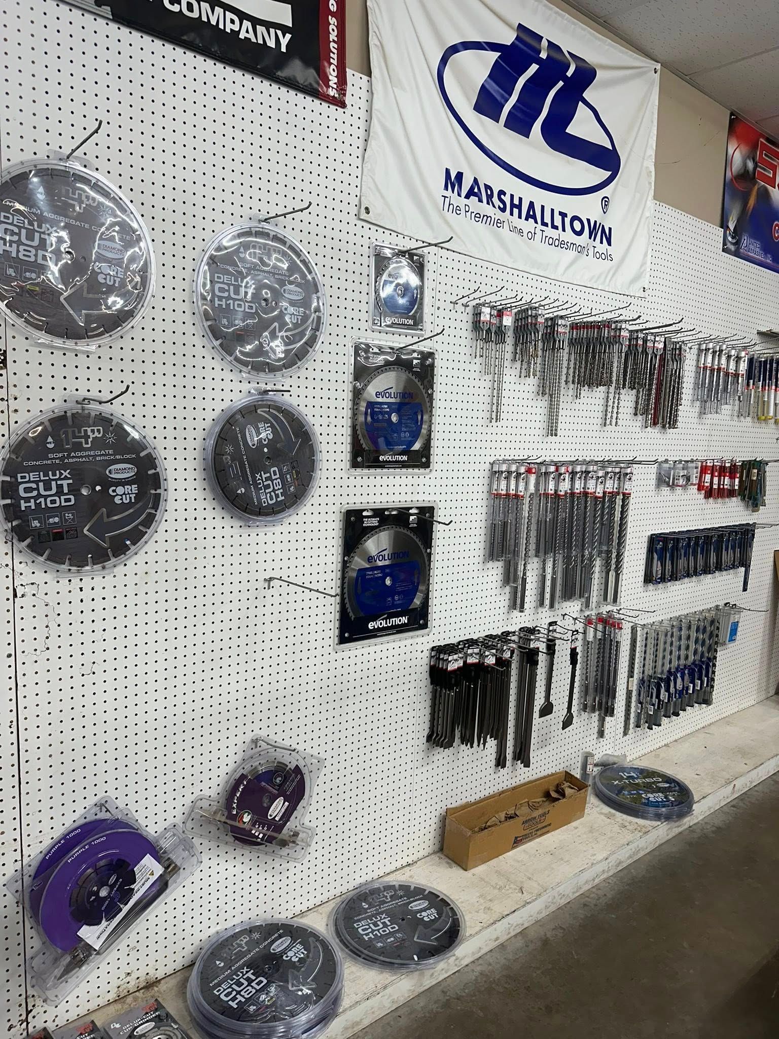 Shelves displaying exercise equipment and fishing lures in a store; weights and a Marshall University flag are visible.