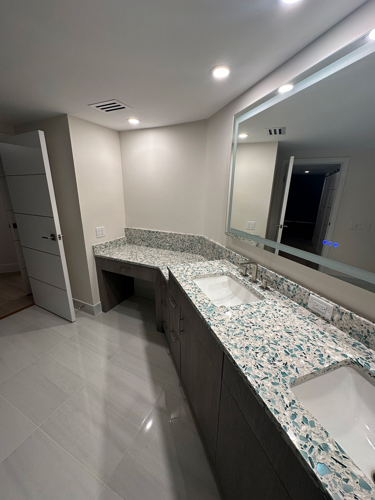 Bathroom with granite countertops, two sinks, large mirror, and accessible sink space.