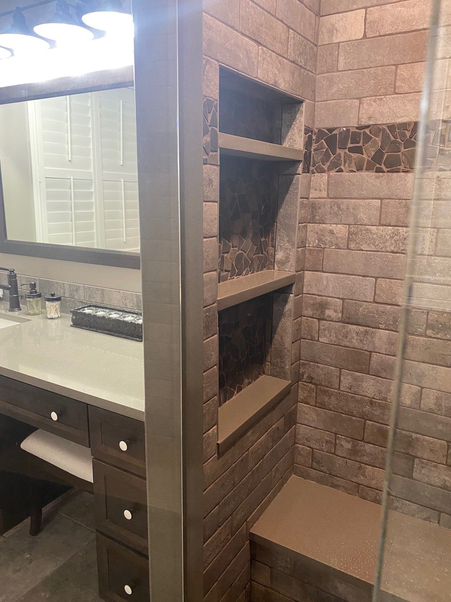Bathroom with a shower featuring tiled walls and a built-in shelf.