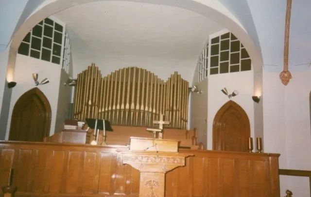 The inside of a church with a podium and an organ