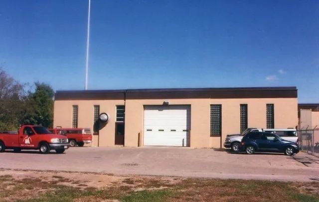 Two red trucks are parked in front of a building