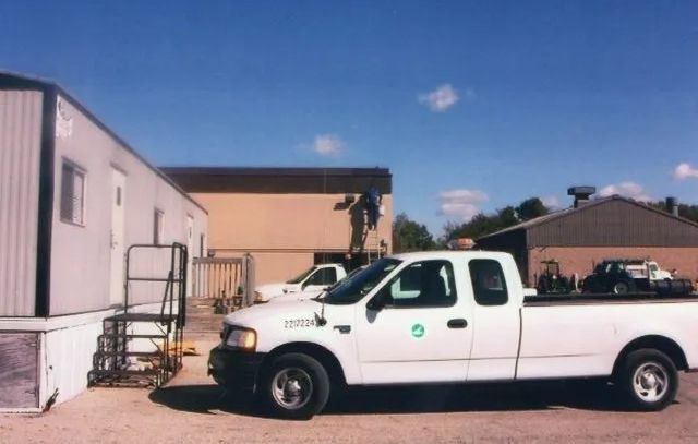A white truck is parked in front of a building