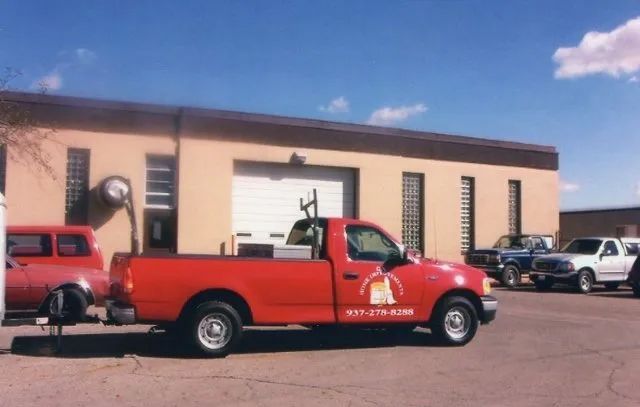 A red truck is parked in front of a building