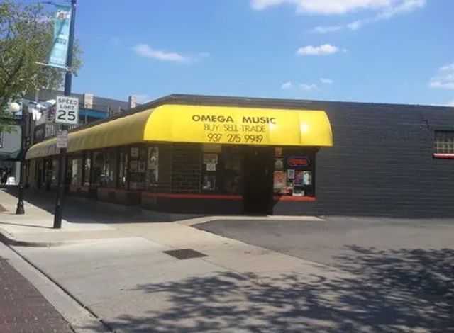 A building with a yellow awning that says omega music