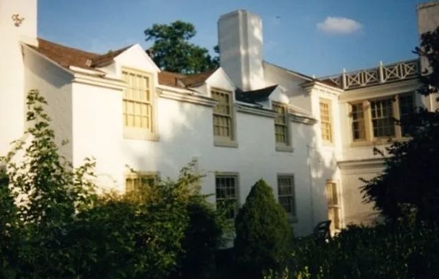 A large white house with a chimney on the top of it