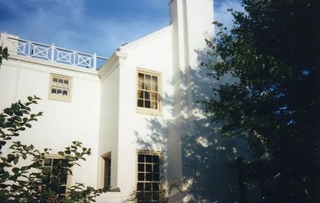 A white building with a balcony on top of it