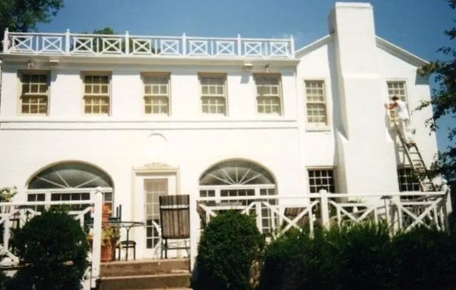 A white house with a ladder on the side of it