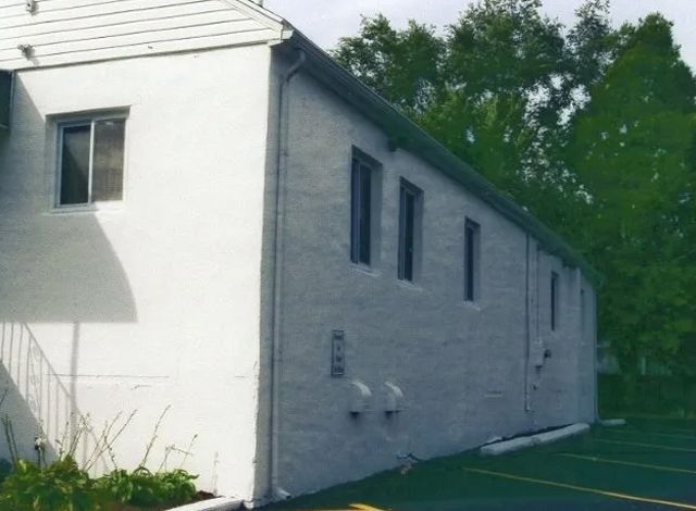 A white building with a parking lot in front of it