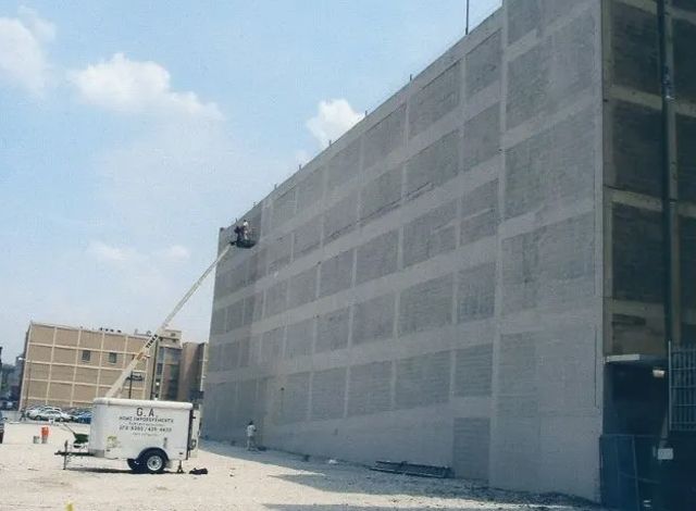 A white van is parked in front of a large building