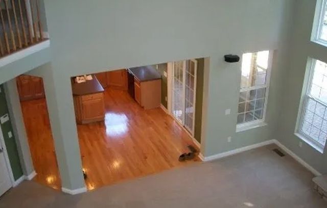 An aerial view of a living room with hardwood floors and a balcony.