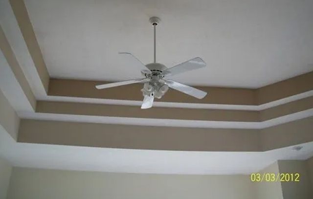 A ceiling fan is hanging from the ceiling of a room.
