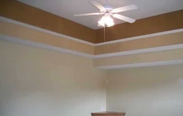 A ceiling fan is hanging from the ceiling of a room.
