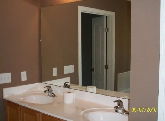 A bathroom with two sinks and a large mirror