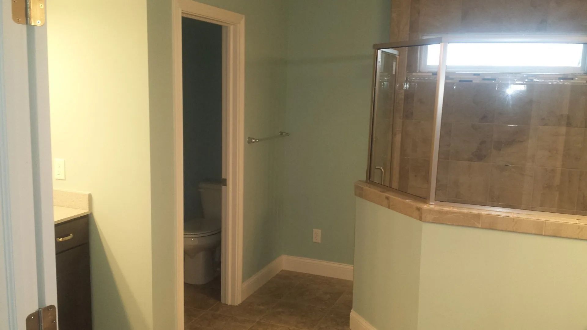 A bathroom with a toilet, sink, and shower stall.