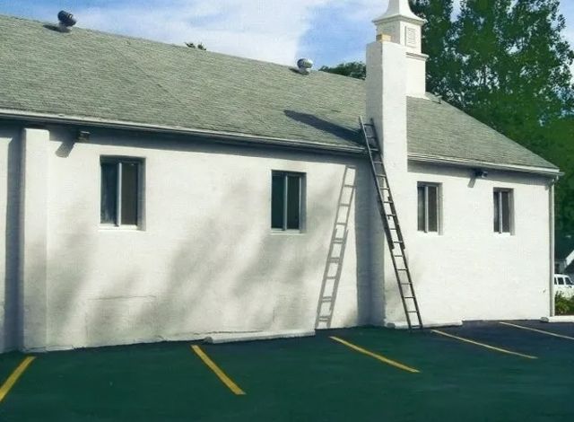 A white building with a ladder leaning against it
