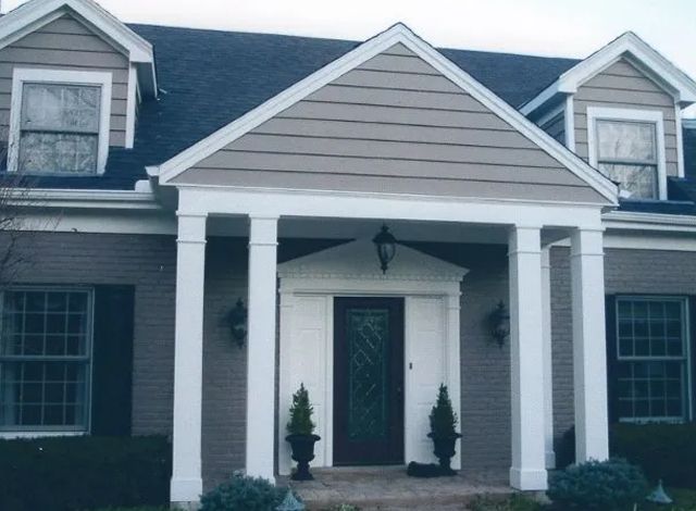 A house with a porch and a black door