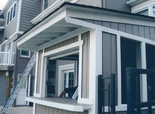 A house with a screened in porch and a ladder in front of it