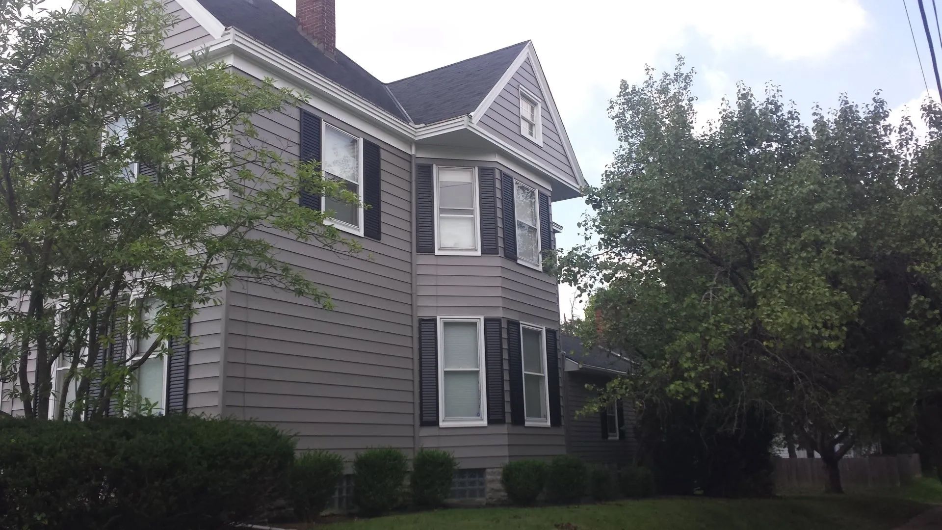 A large house with black shutters on the windows