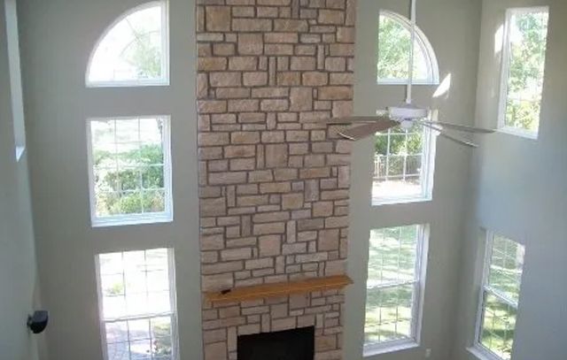 A living room with a fireplace and a ceiling fan