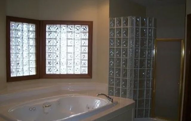 A bathroom with a jacuzzi tub and two windows