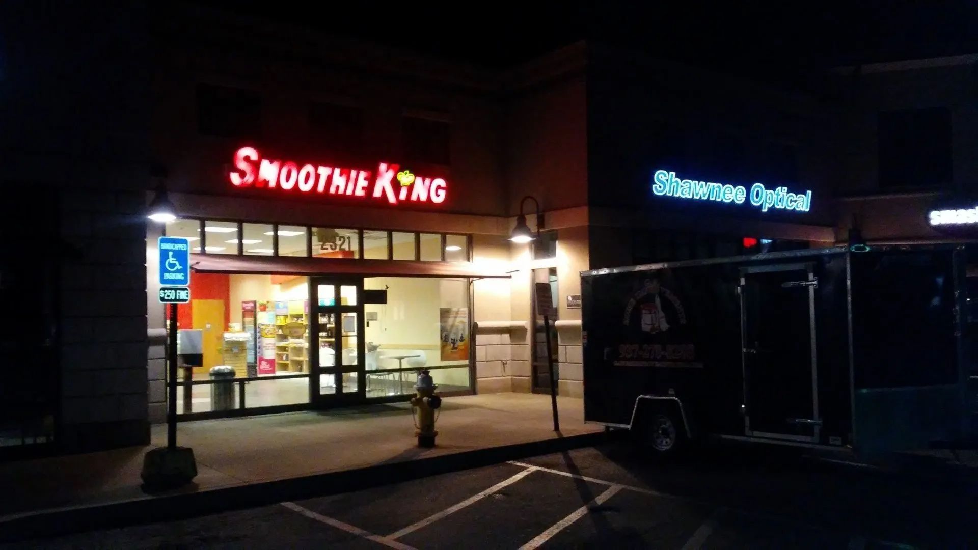 A smoothie king store is lit up at night