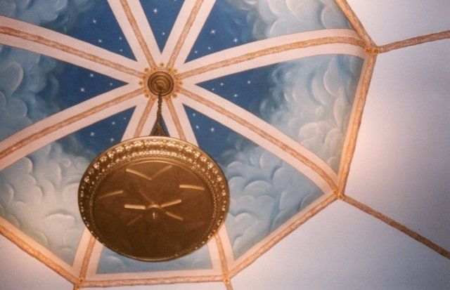 A clock hanging from the ceiling of a building