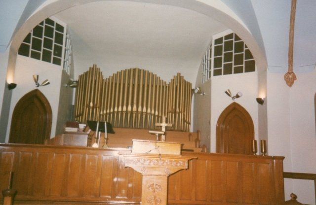 The inside of a church with a podium and an organ