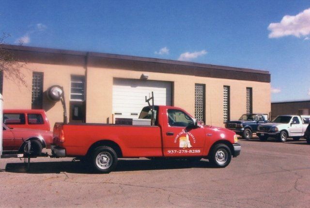 A red truck is parked in front of a building