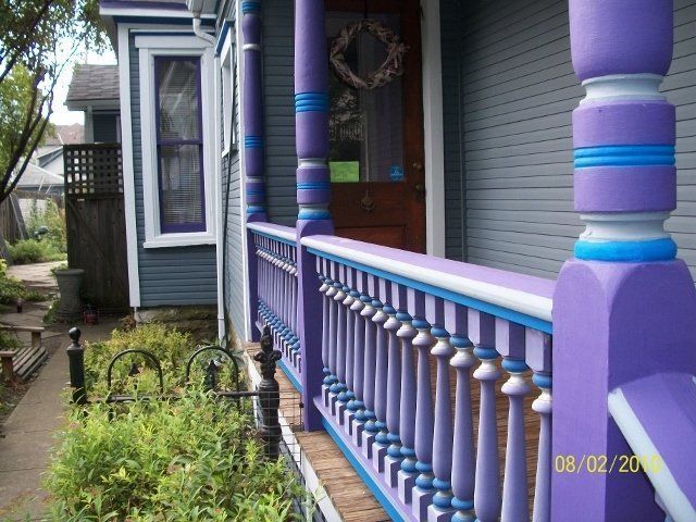 A purple and blue porch with a wreath on the door