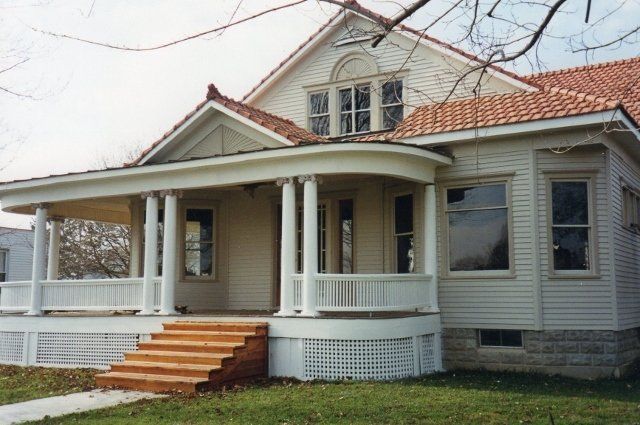 A white house with a large porch and stairs