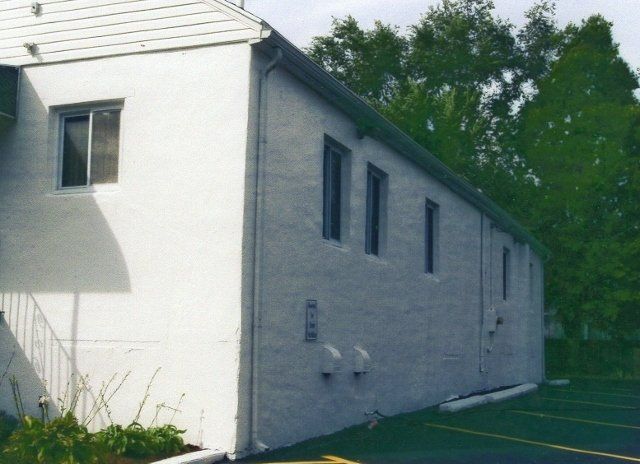 A white building with a parking lot in front of it