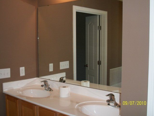 A bathroom with two sinks and a mirror on the wall
