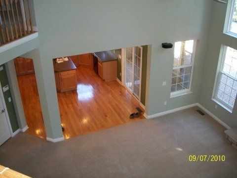 An aerial view of a living room with hardwood floors and a balcony.