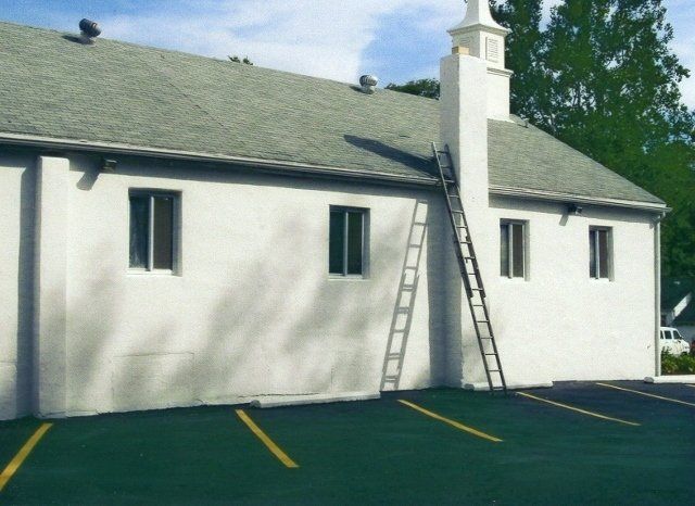 A white building with a ladder leaning against it