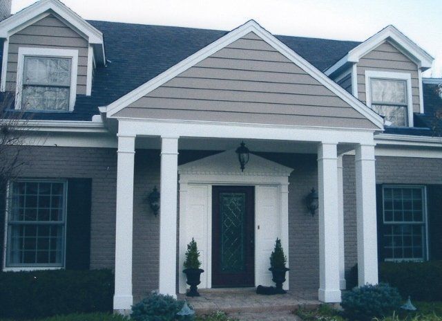 A house with a porch and a black roof