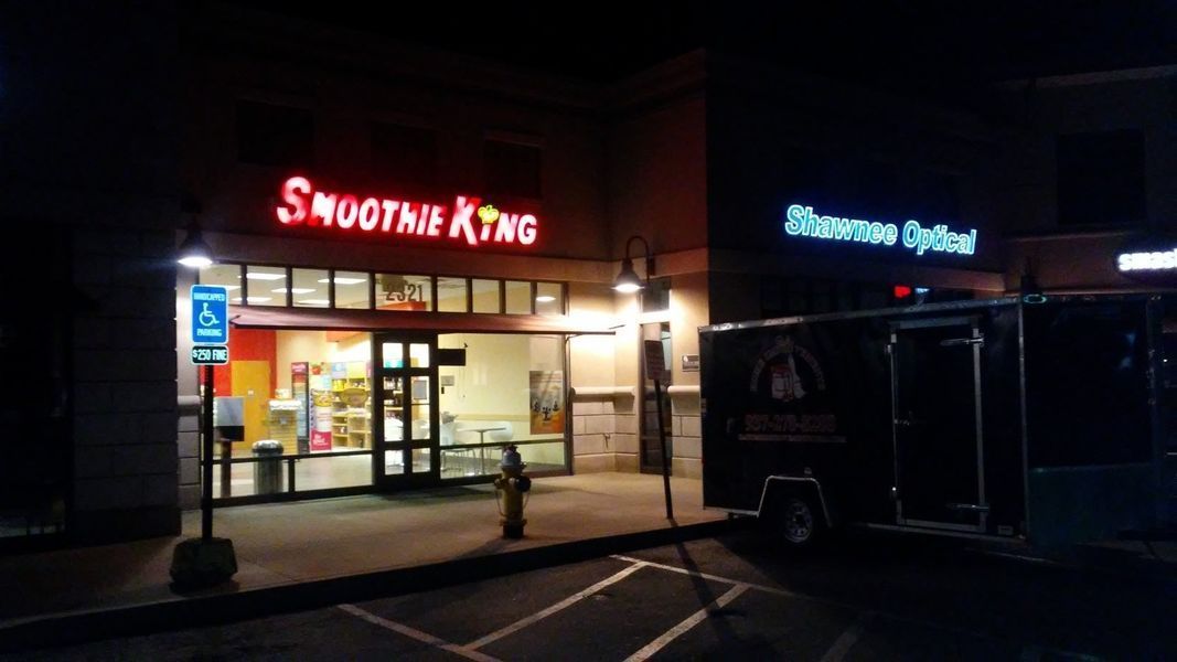 A smoothie king restaurant is lit up at night